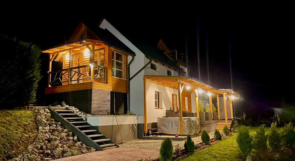A Calm Resort Hertelend vendégház esti megvilágításban, hangulatos terasszal, meleg fényekkel, természetközeli környezetben