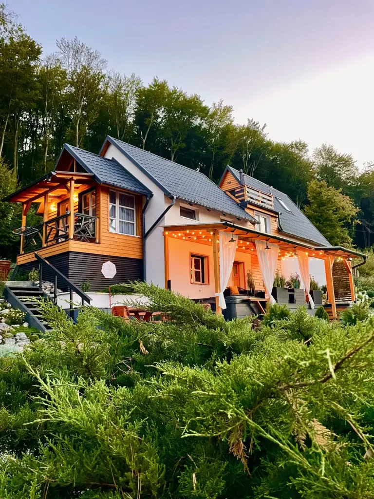 A magyarhertelendi Calm Resort modern, erdei környezetben álló, hangulatos vendégháza terasszal és meleg fényekkel